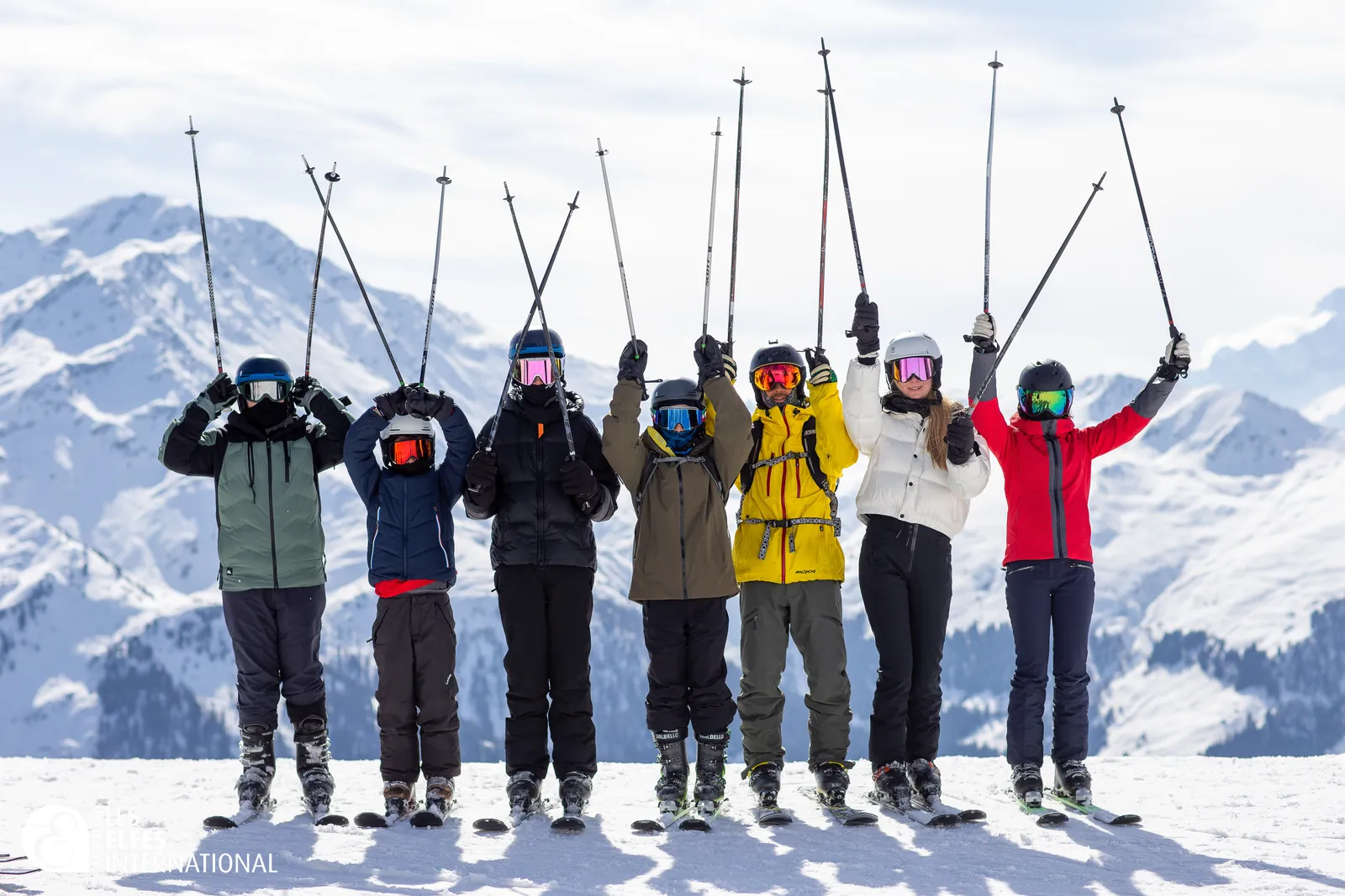 Campers raising their ski poles on the slopes